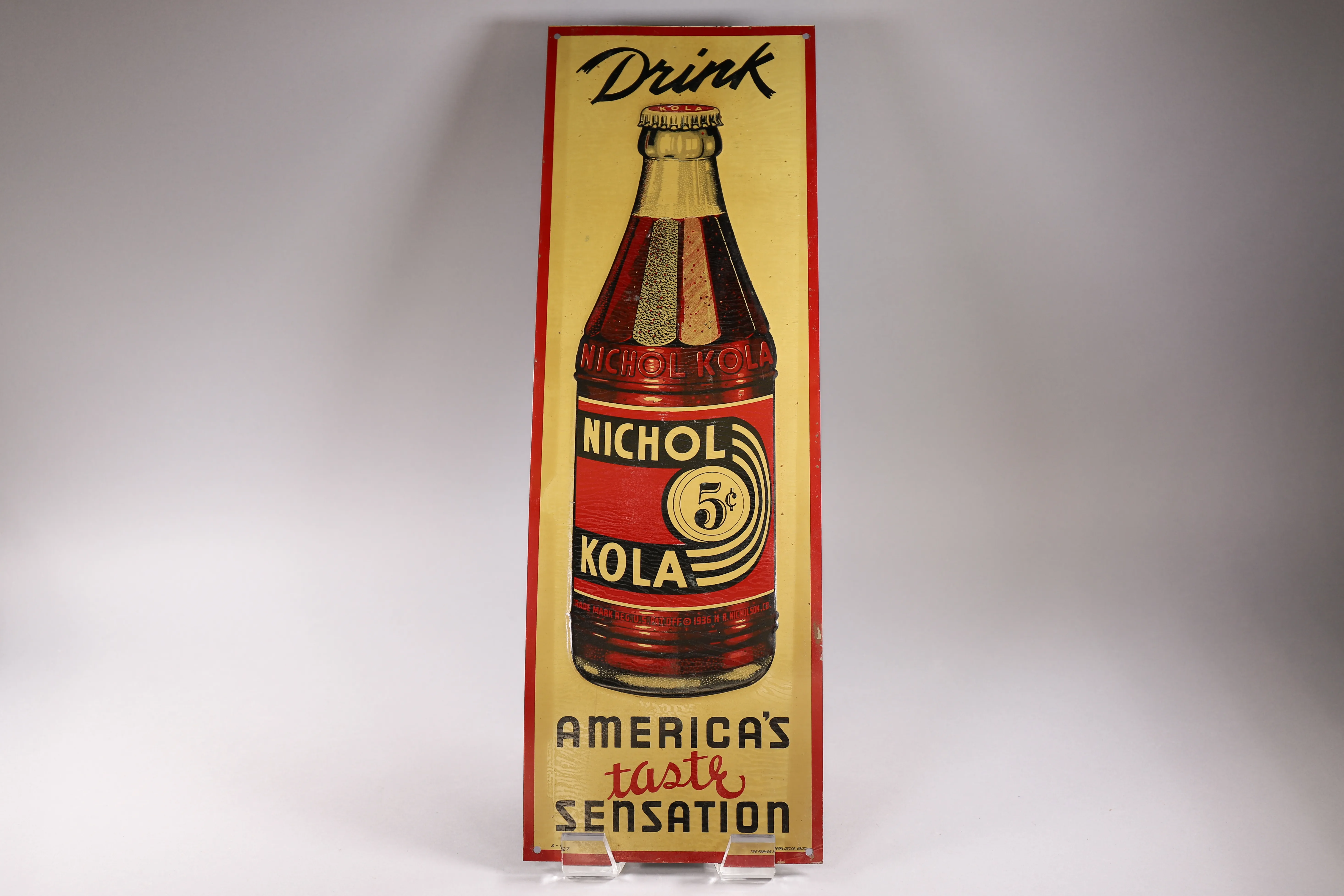 Tall vintage Nichol Kola bottle sign photographed as an estate sale collectible.