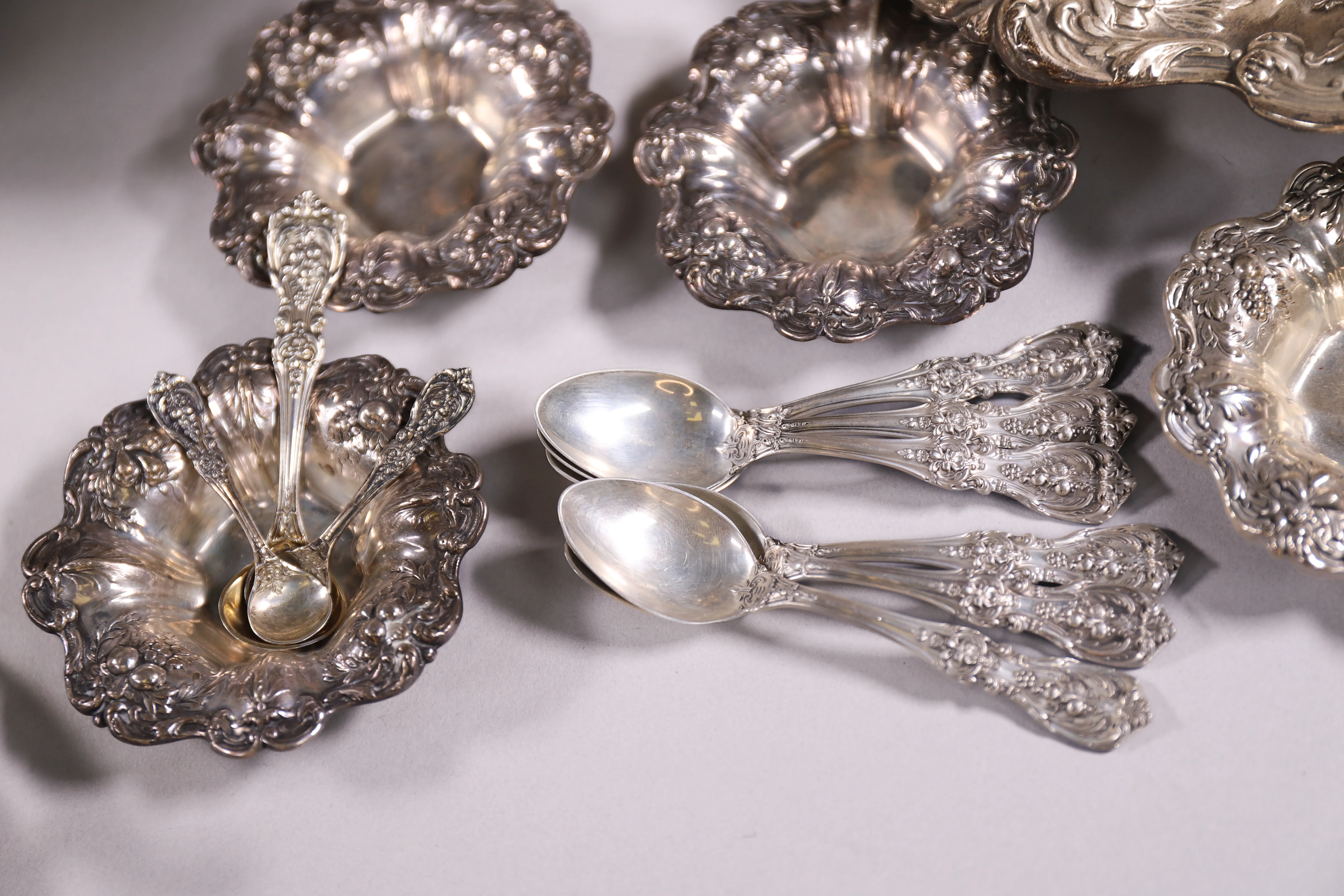 Detailed silver flatware and serving pieces arranged for estate sale review.
