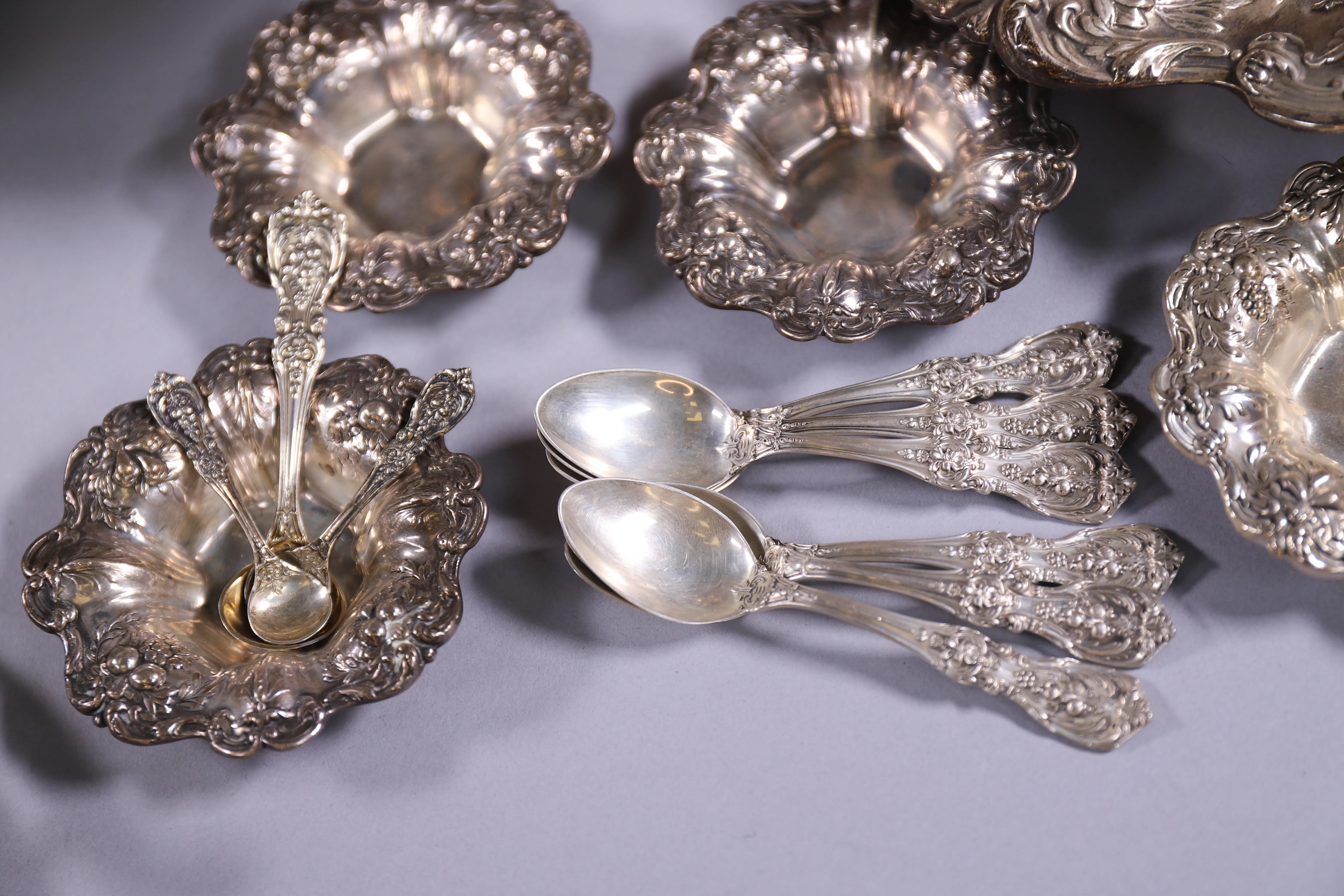 Close arrangement of silver spoons and bowls photographed as estate sale finds.